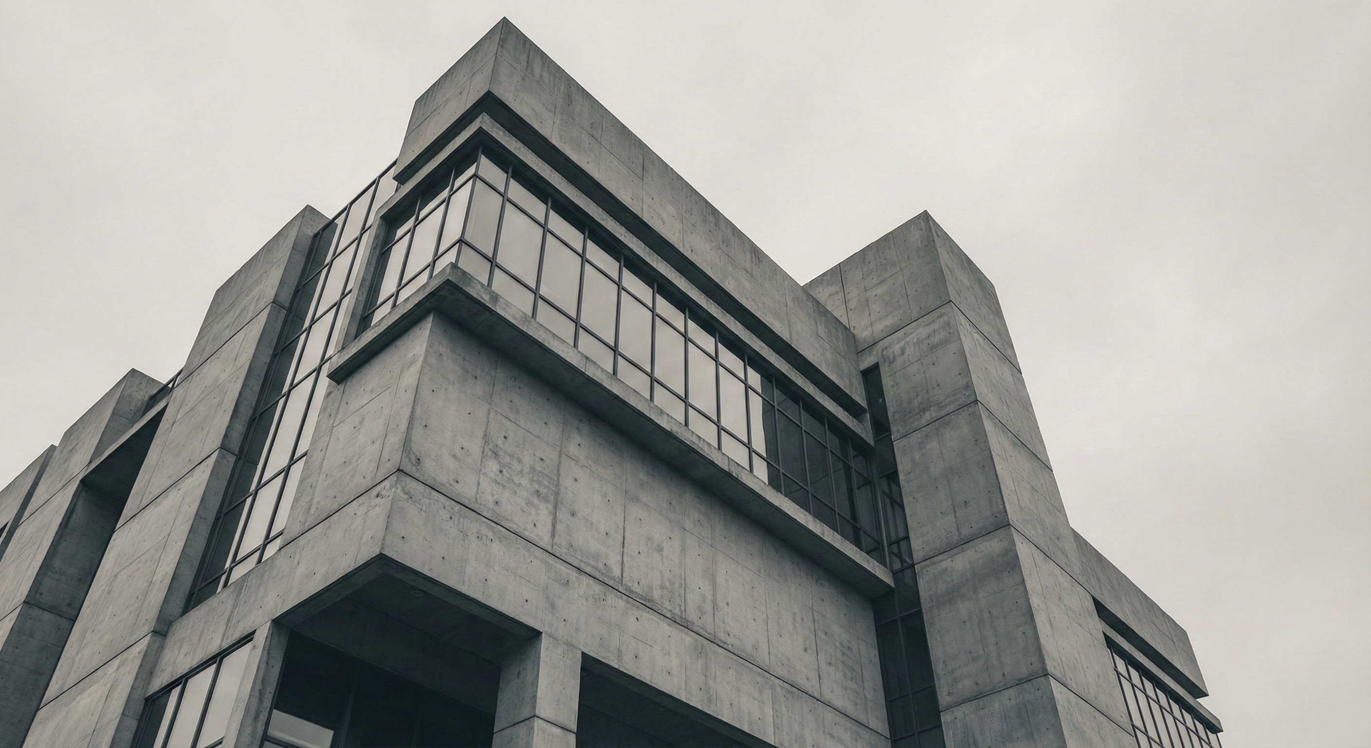 Modern concrete building exterior with minimal architectural detail, conveying permanence and institutional stability